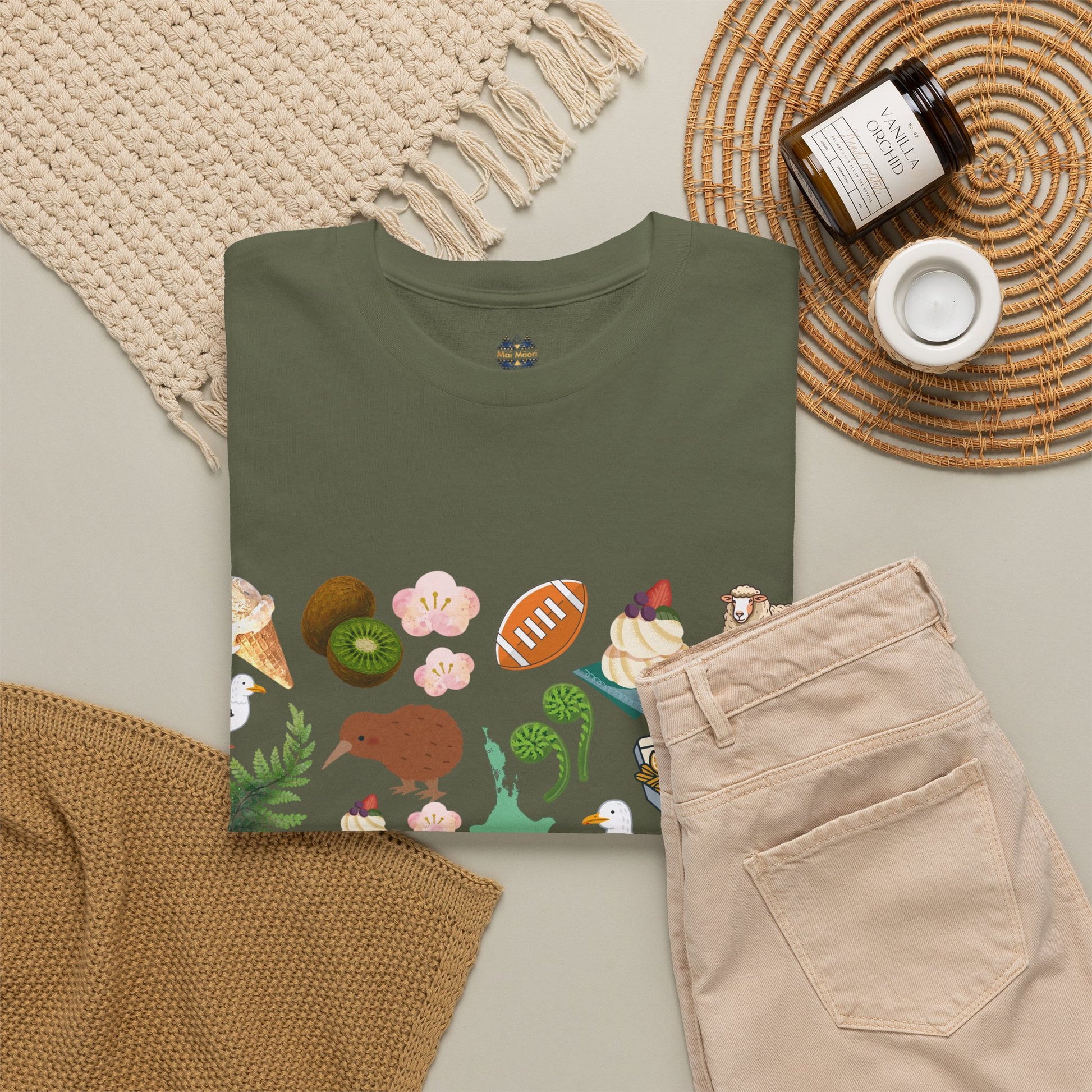 Dark green crewneck T-shirt with small chest logo and colorful Kiwiana-themed print