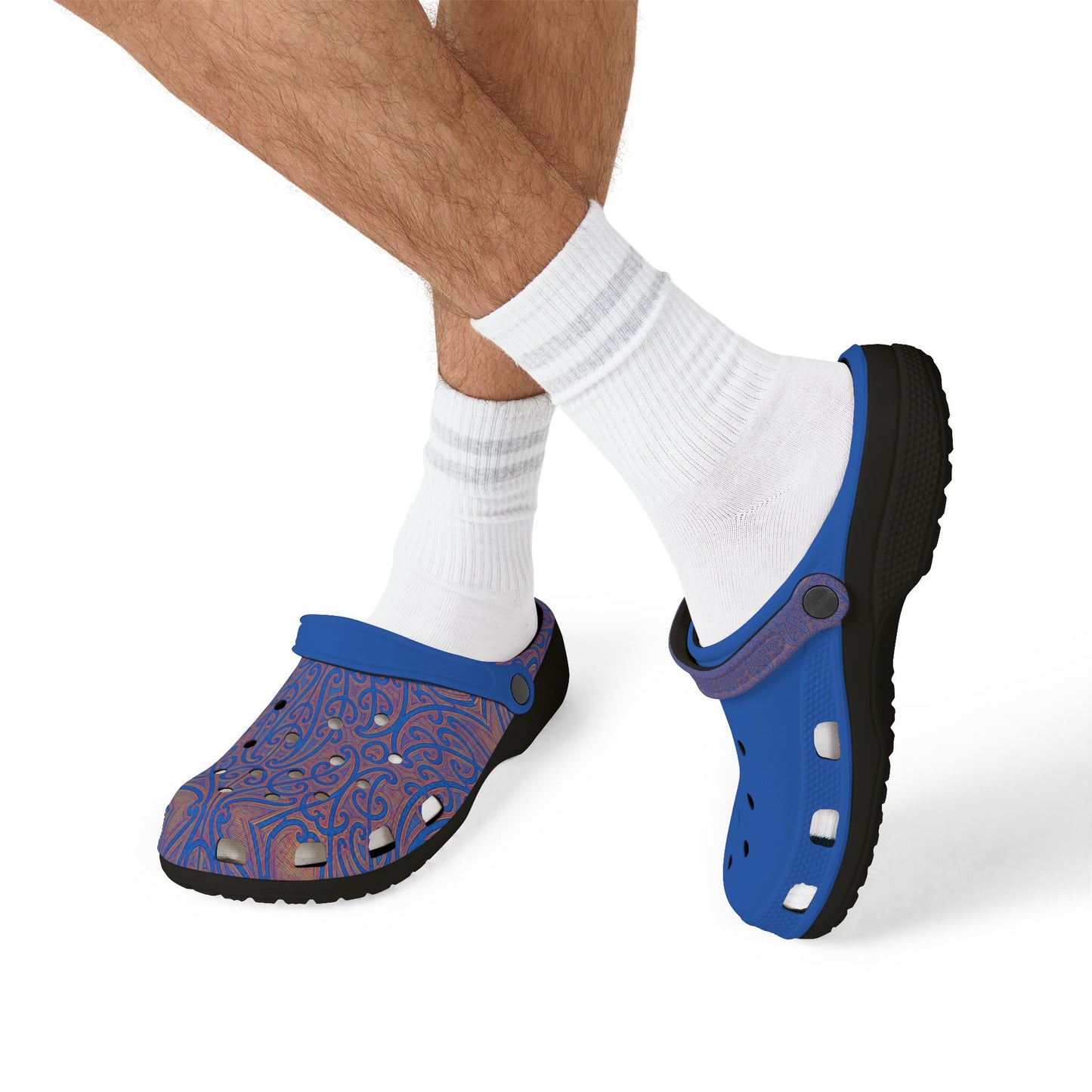 Blue and purple patterned clogs on a person’s feet with white socks.
