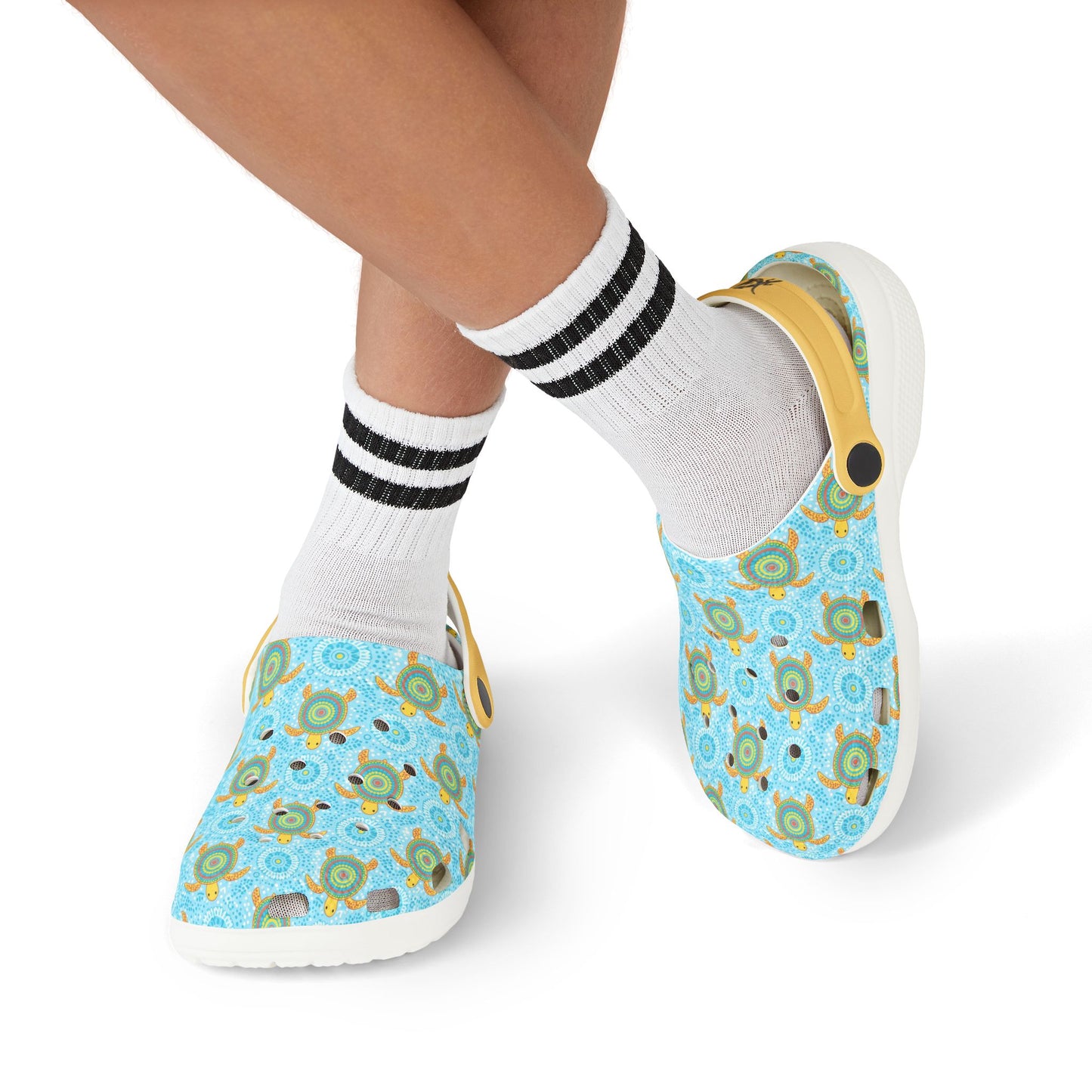 Pair of light blue turtle-pattern clog shoes on feet with white socks and black stripes