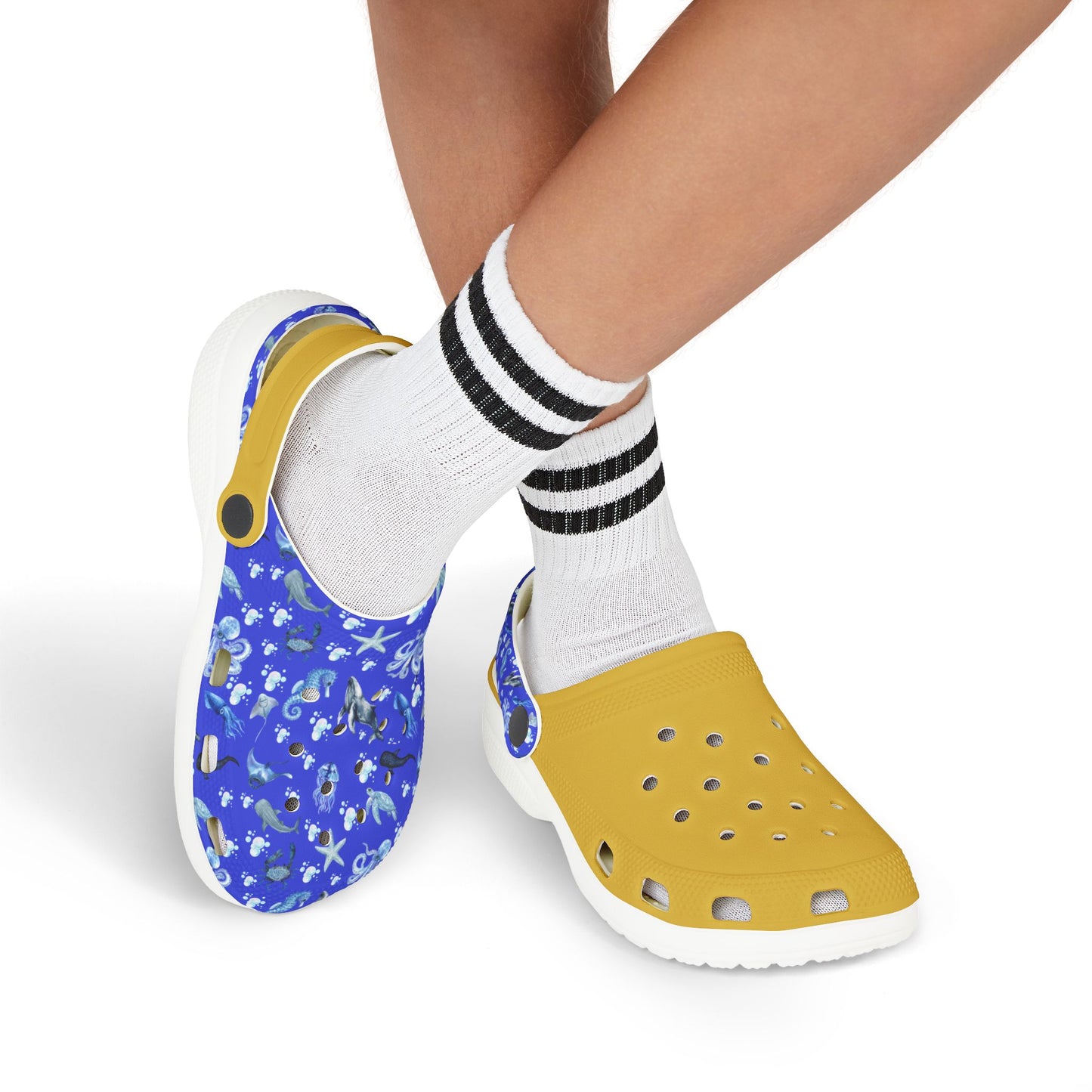 Kids' clog shoes on feet: blue sea-print upper and yellow perforated back, white sole.