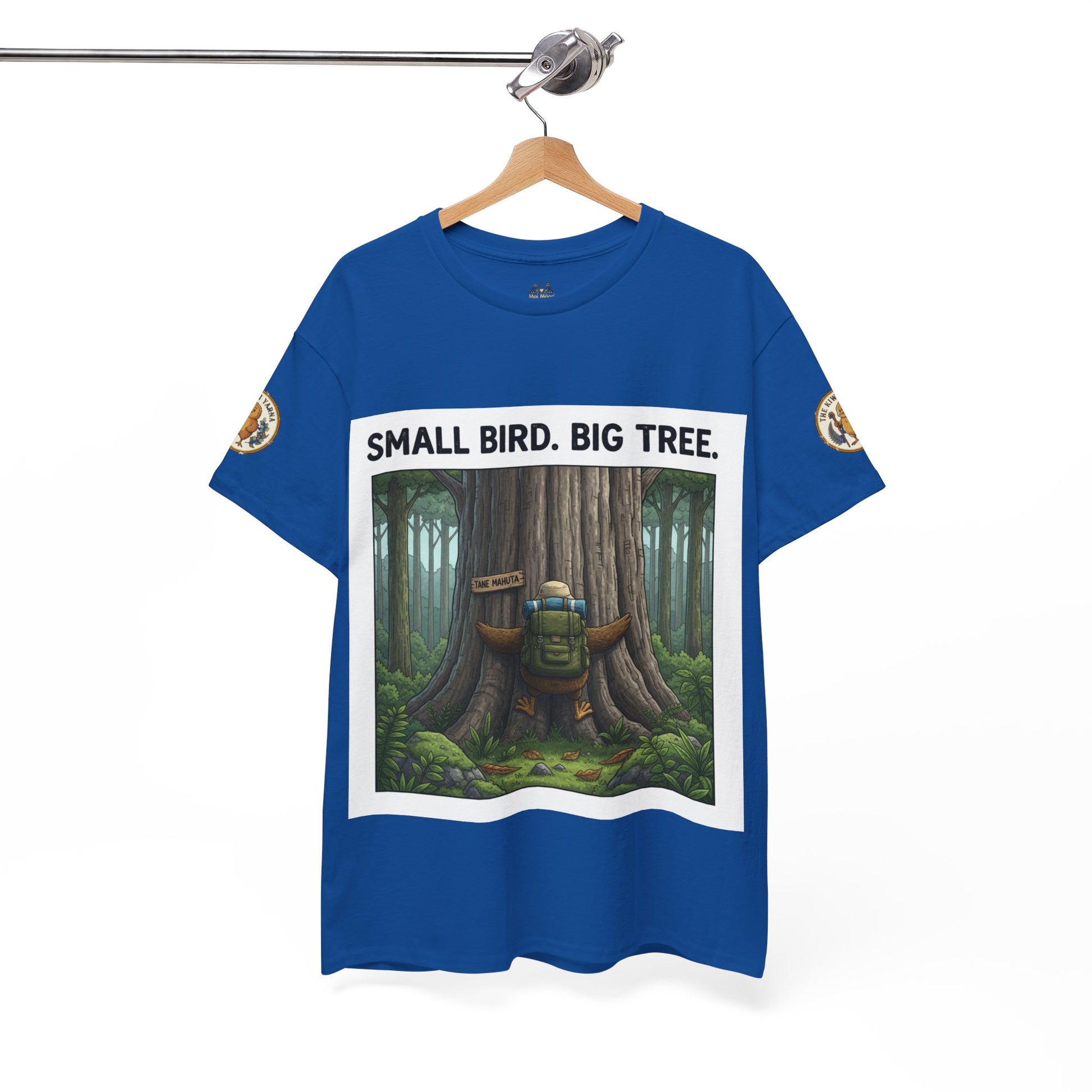 Blue crew-neck T-shirt hanging up with centered “Small Bird. Big Tree.” forest graphic