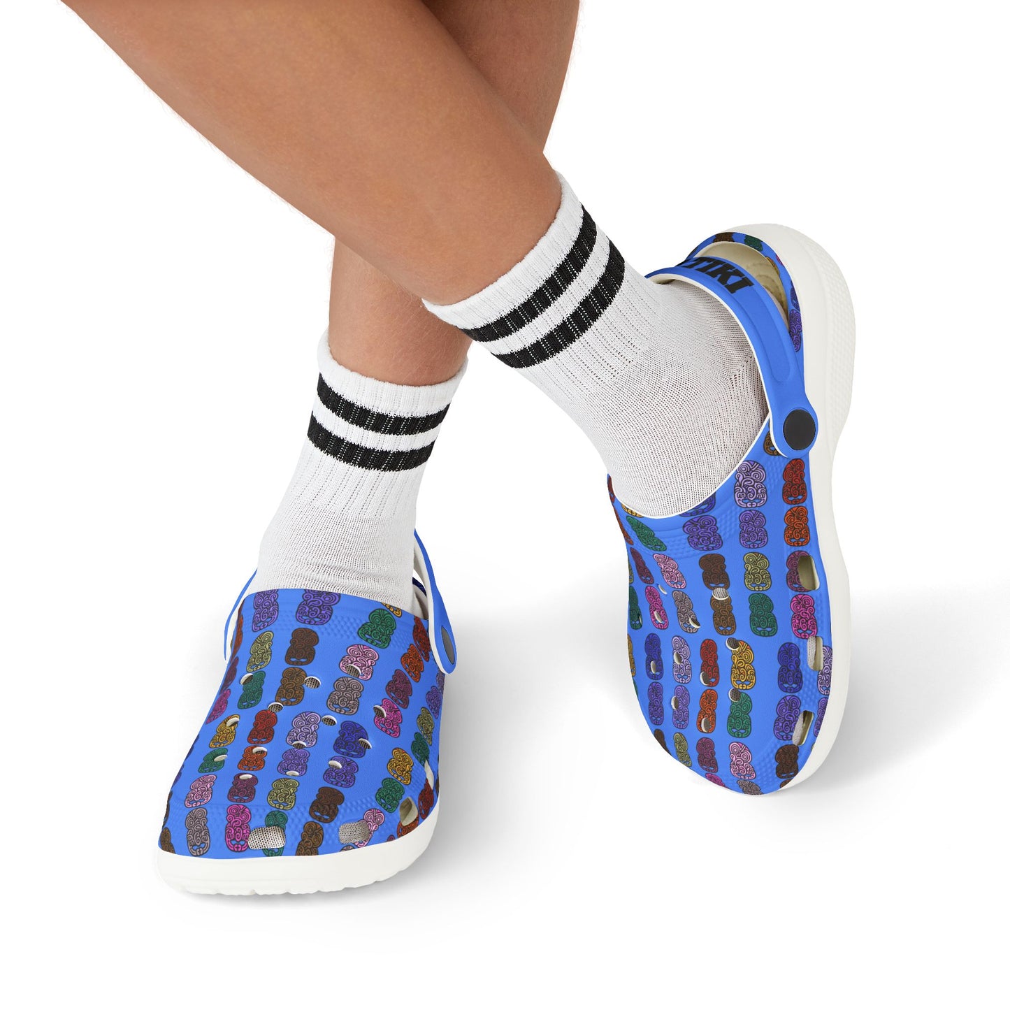 Kids slip-on casual shoe worn with white socks and black stripes, blue tiki-print upper