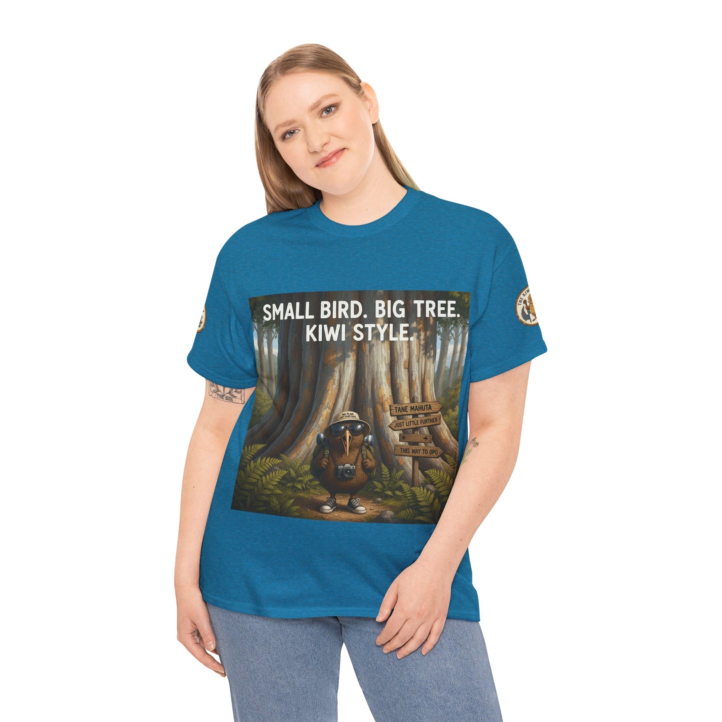 Teal graphic T-shirt folded stack with front poster design and 'KIWI STYLE'