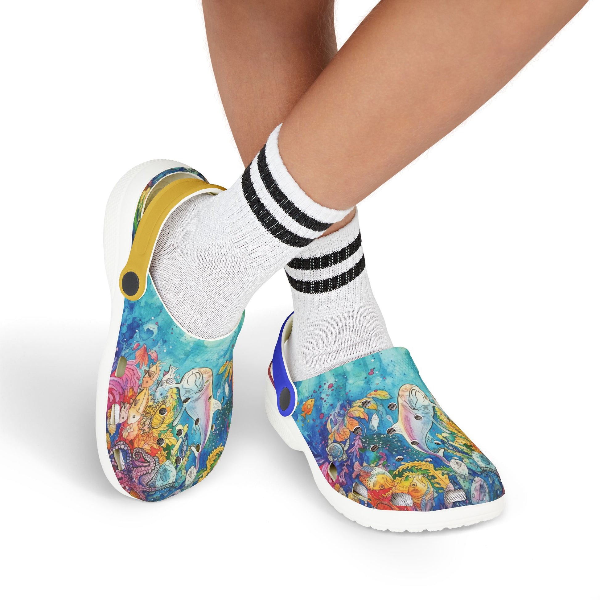 Kids slip-on clogs worn with white socks; colorful reef print and blue heel strap accent.