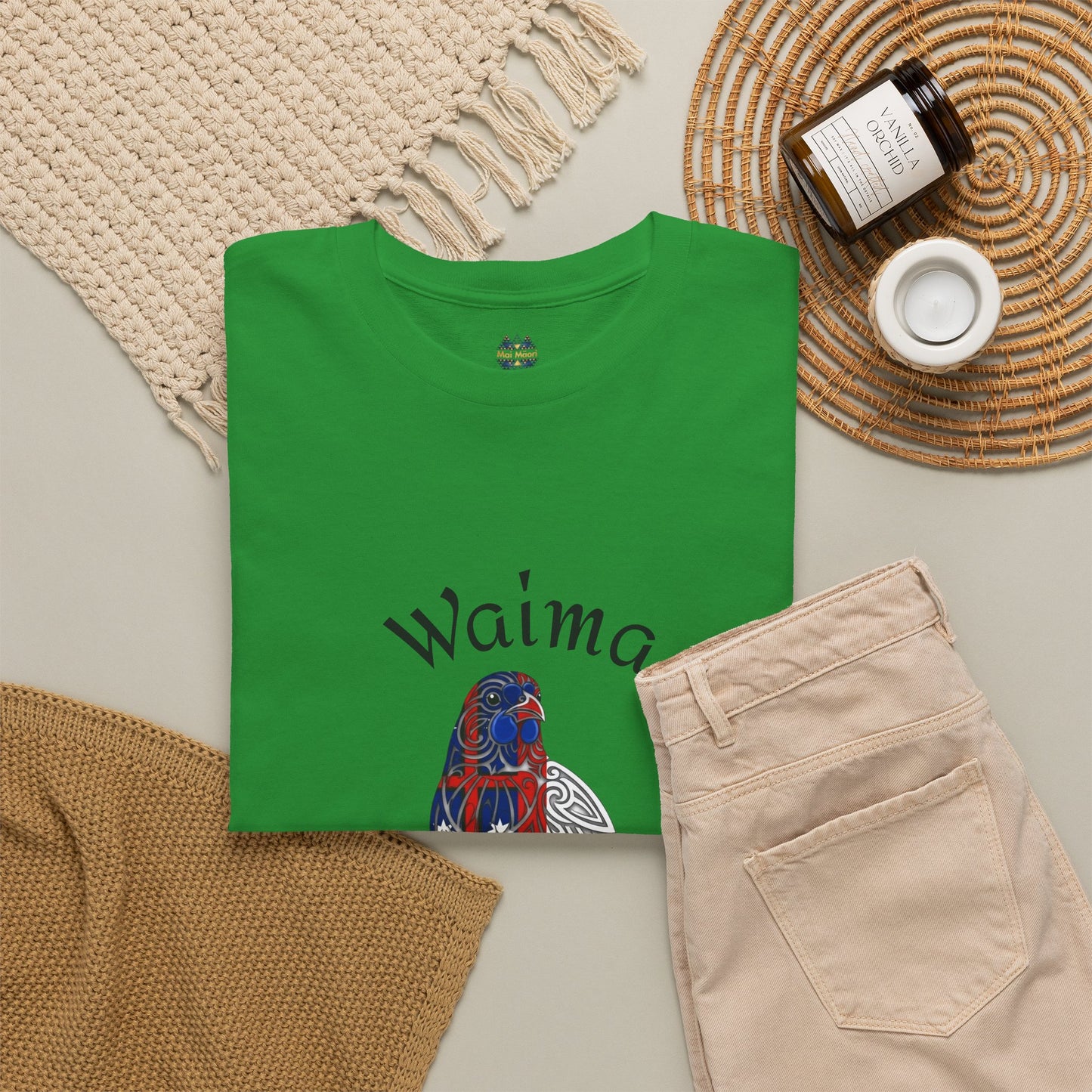 Green T-shirt laid flat with colorful bird graphic and arched text print