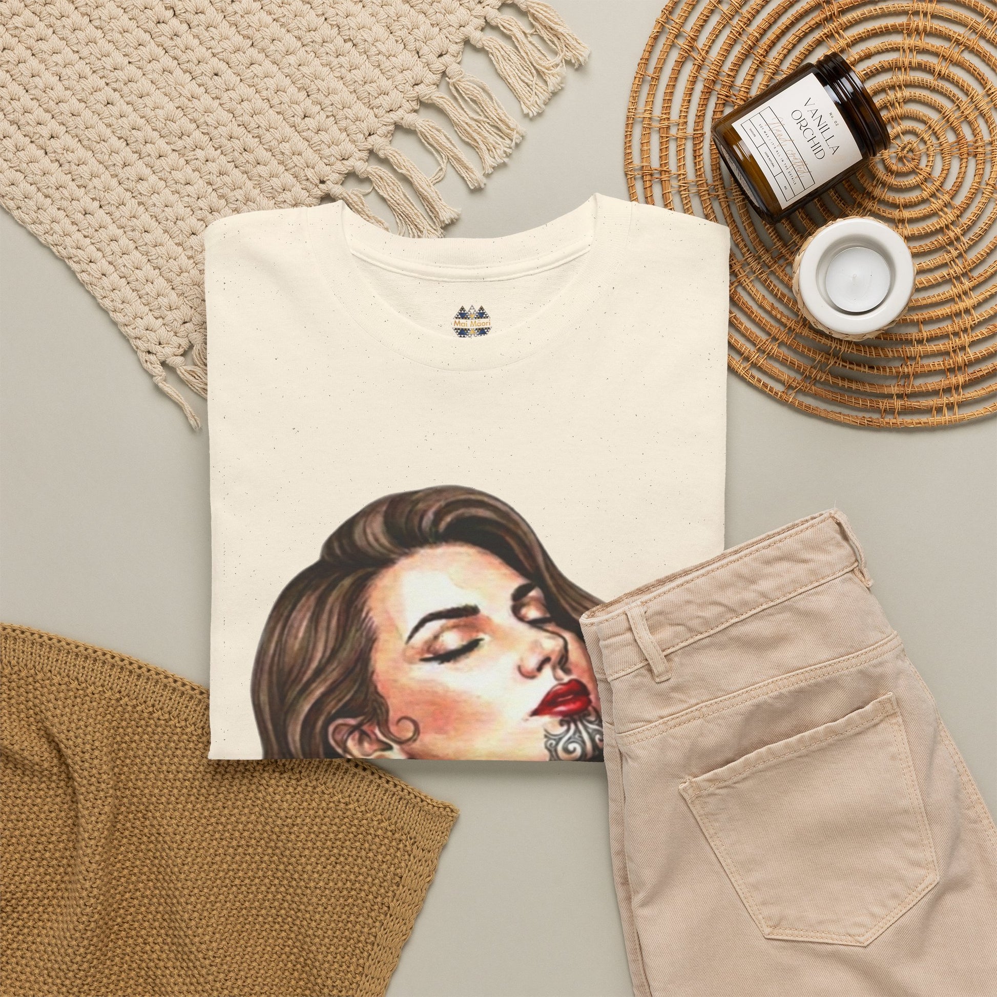 Cream T-shirt with large portrait graphic and decorative sleeve patches; crew neckline