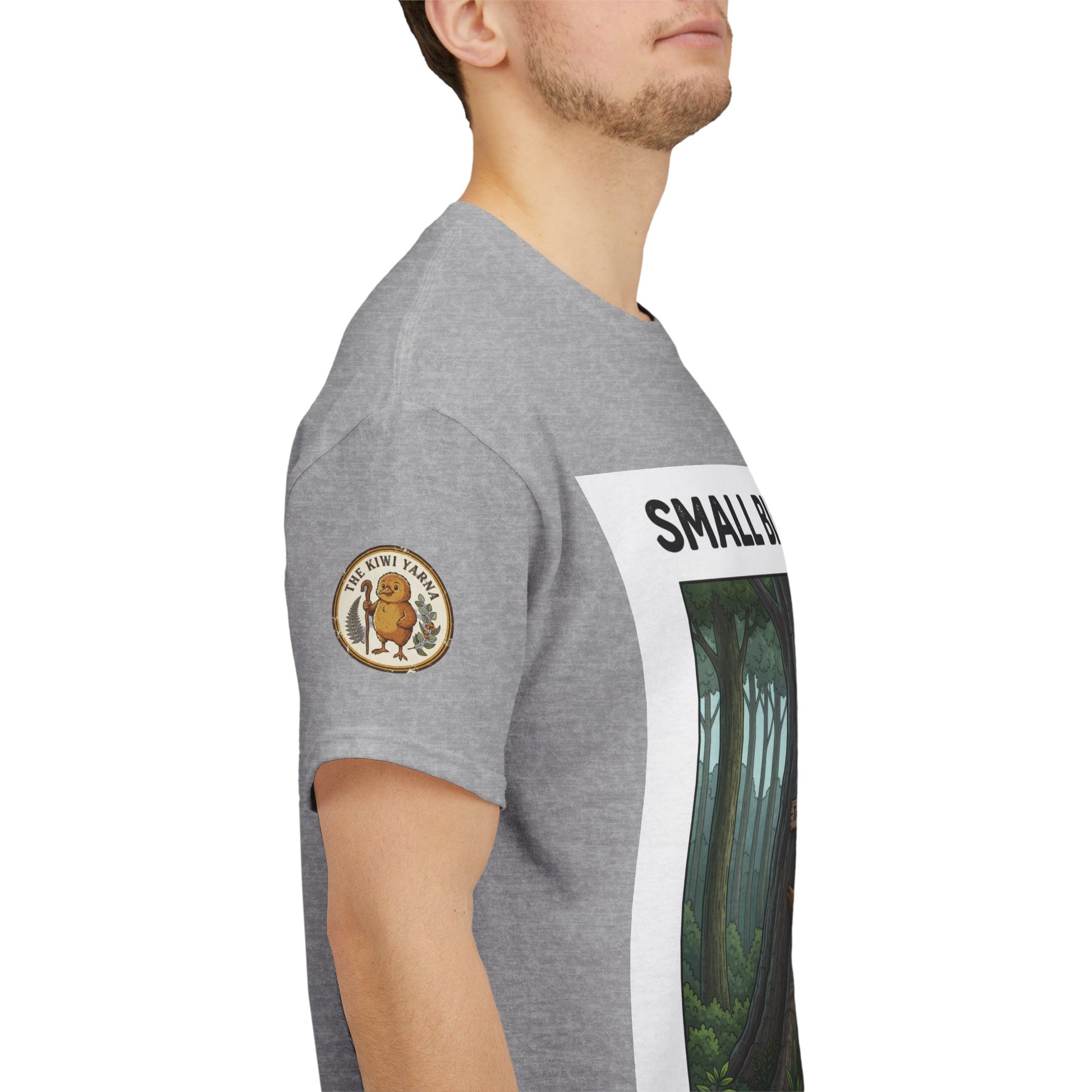 Gray T-shirt side view with circular logo patch and partial forest graphic