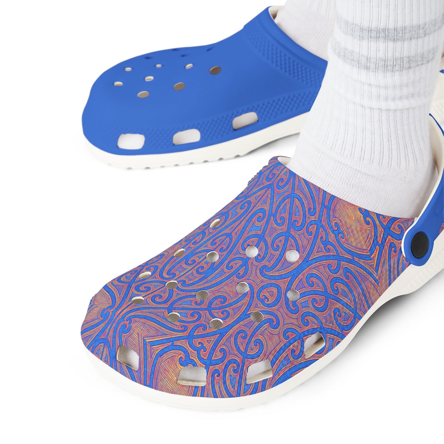 Māpouriki slip-on clogs on feet with white socks; patterned upper and blue toe section