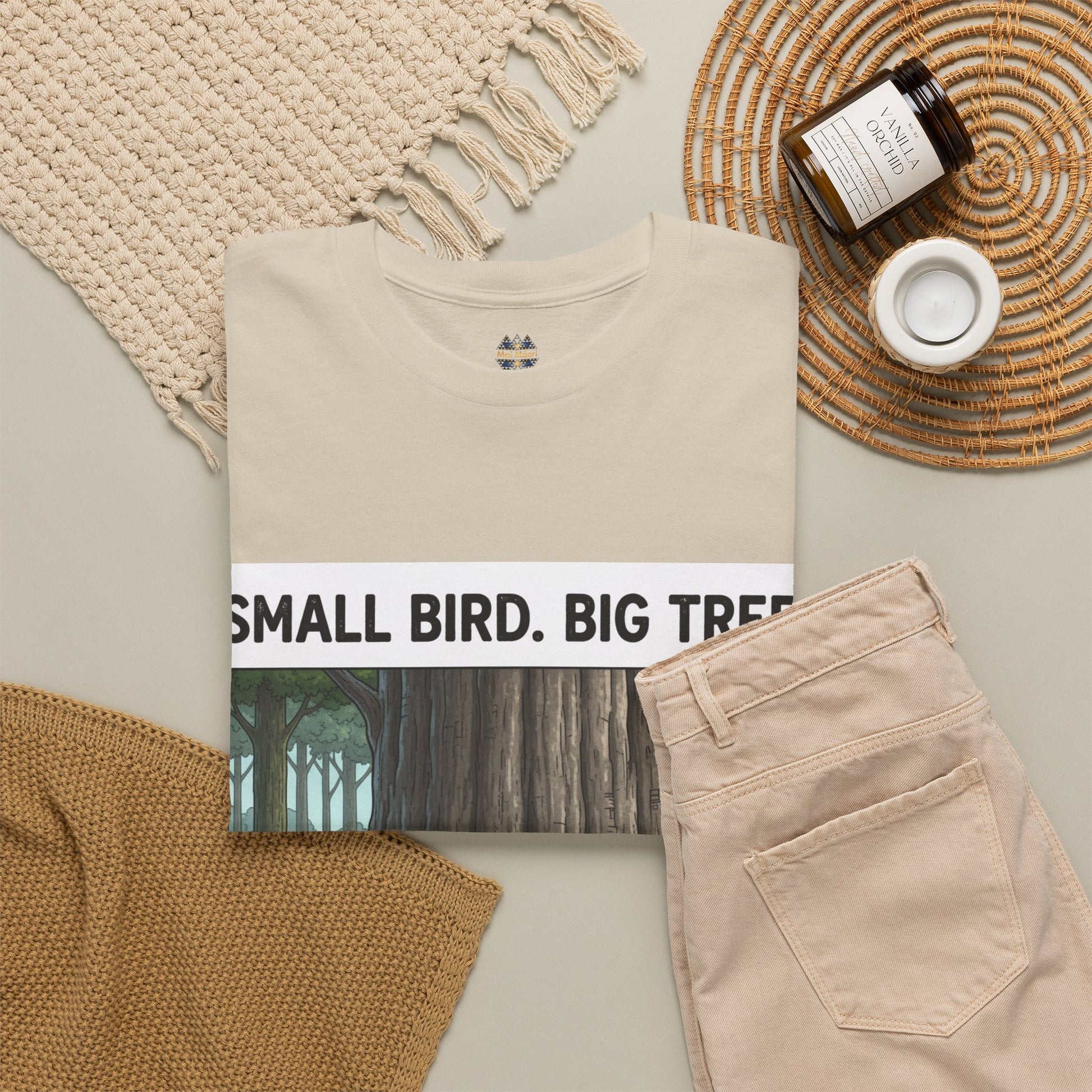 Beige T-shirt chest graphic partially visible with 'SMALL BIRD. BIG TR' text