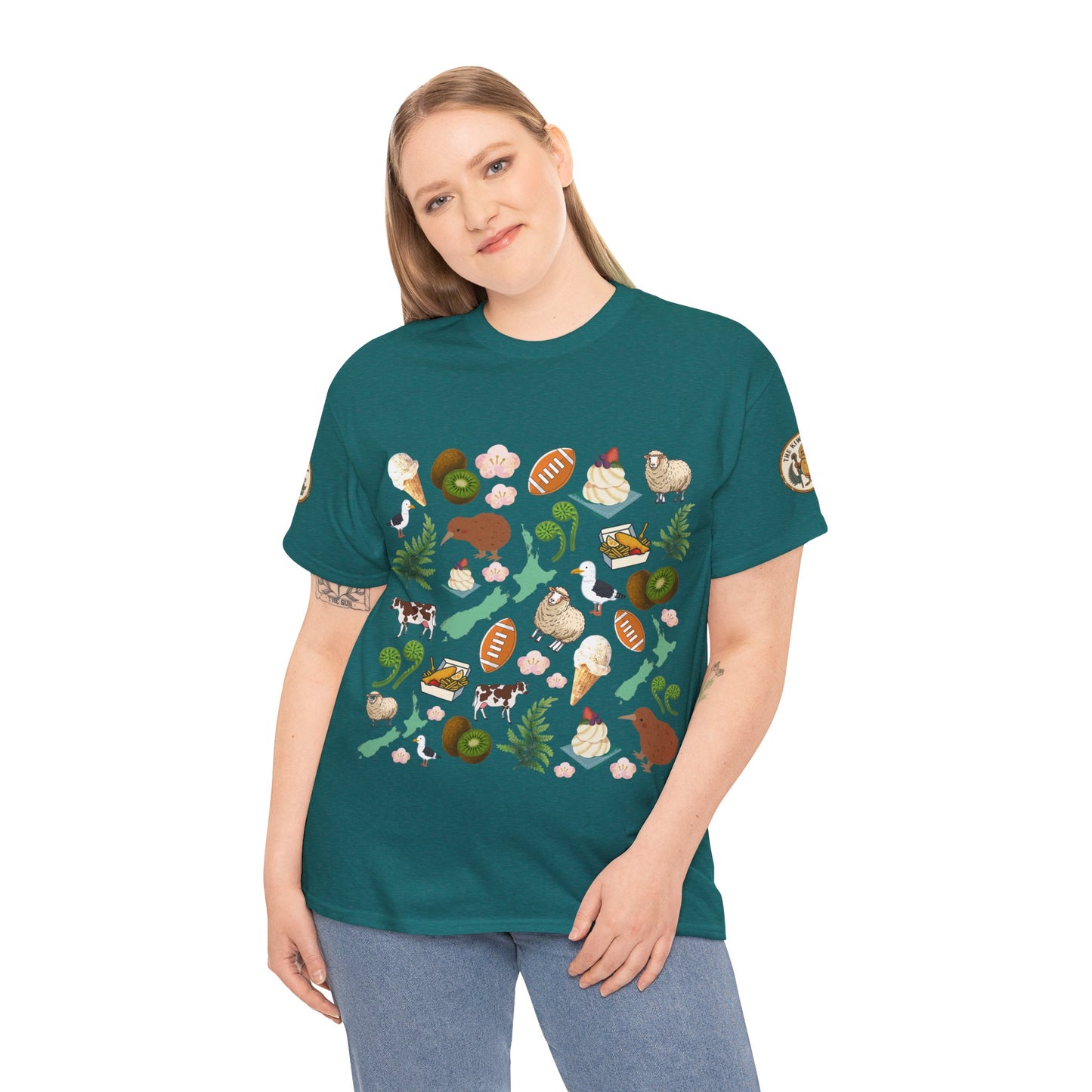 Teal crewneck T-shirt on model with scattered Kiwiana-themed icons and animals (front)