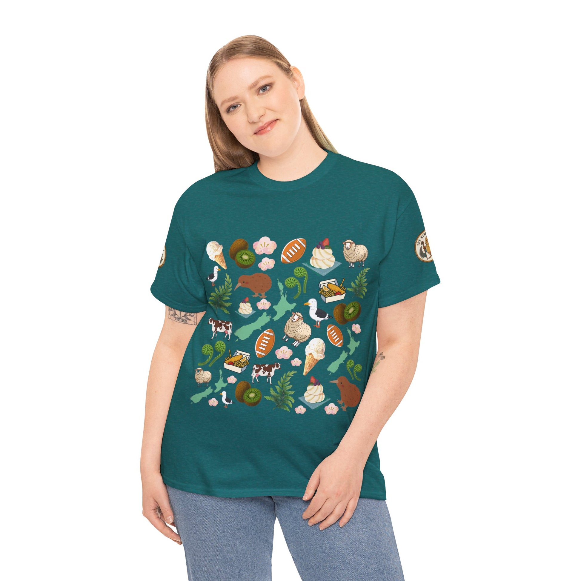 Teal crewneck T-shirt on model with scattered Kiwiana-themed icons and animals (front)