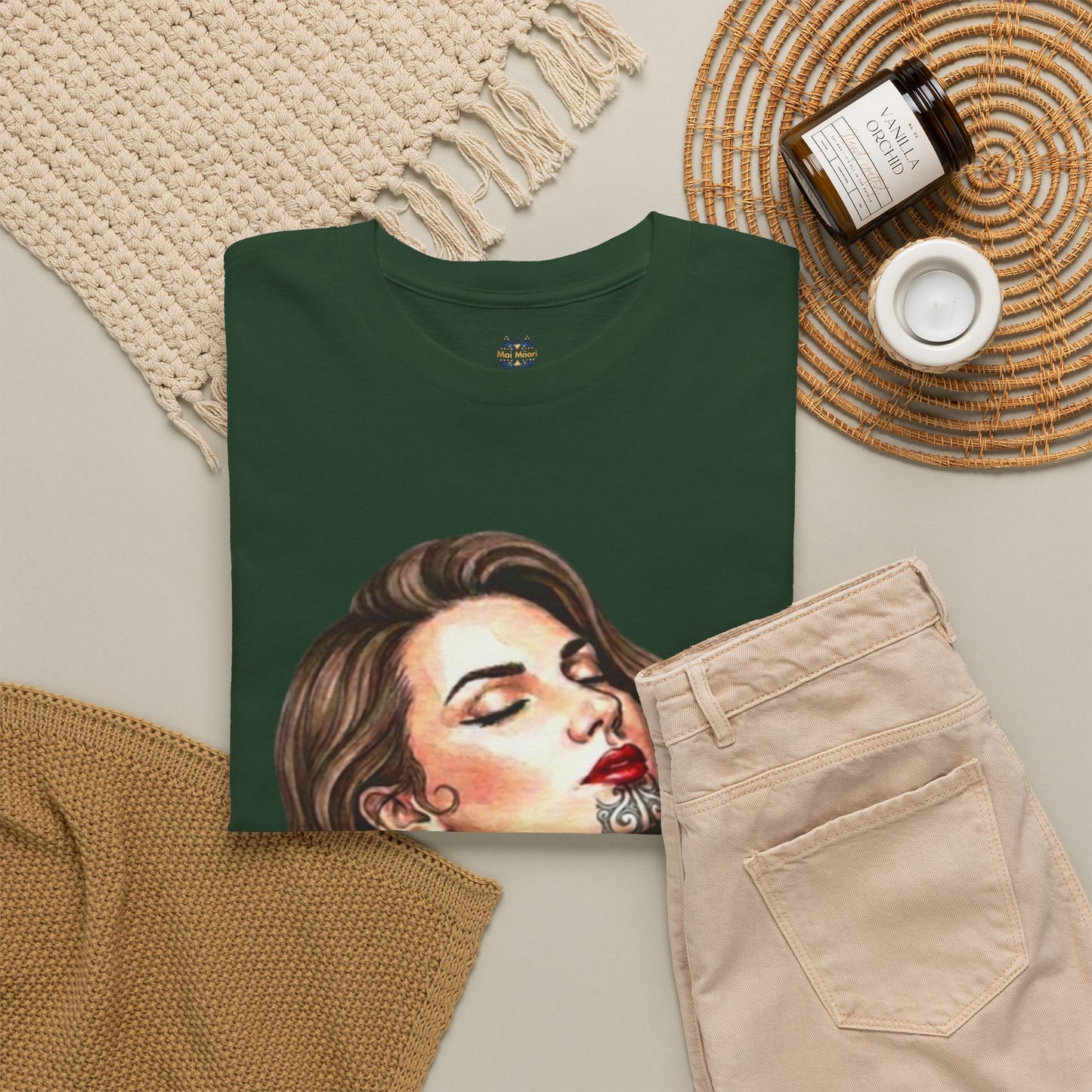 Dark green graphic T-shirt folded flat, woman face portrait print visible.