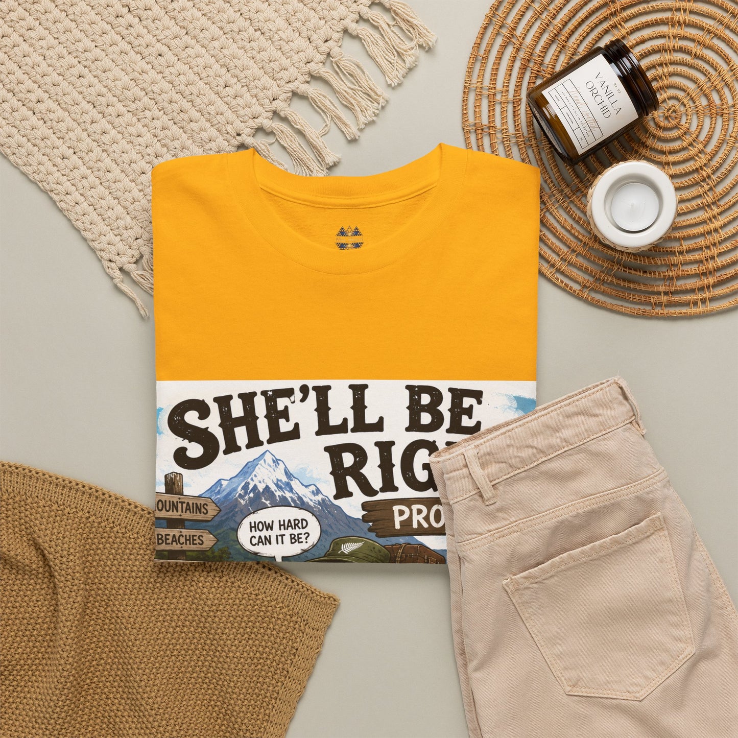 Yellow T-shirt with “She’ll Be Right… Probably” graphic, flat lay styling with folded items