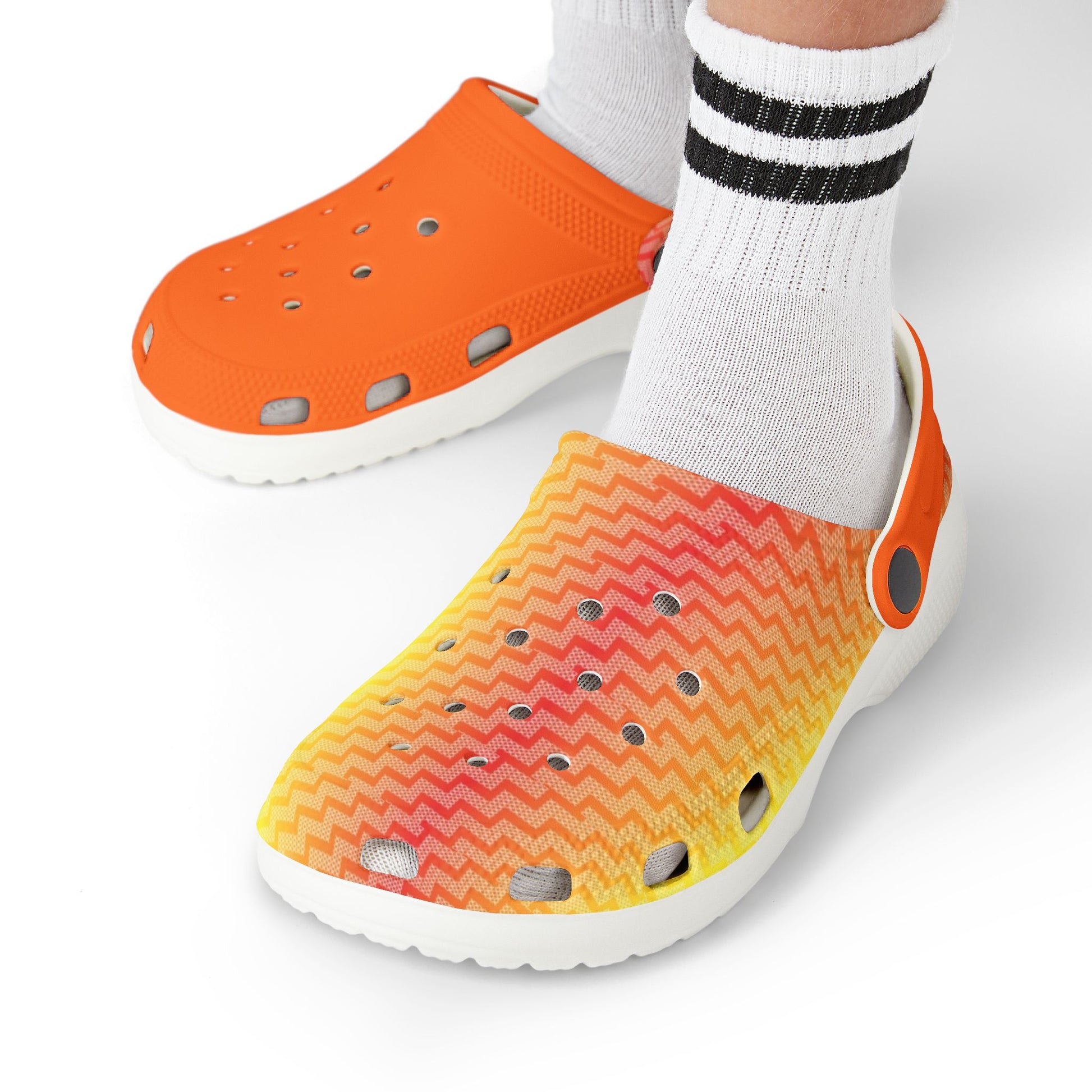 Croc-style clogs being worn: orange upper and multicolor zigzag side with perforations