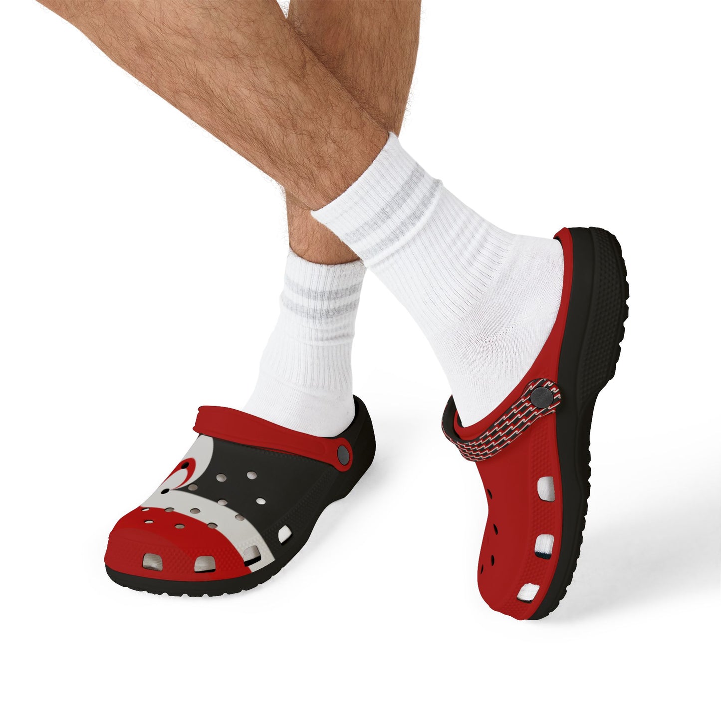 Red and black clogs worn with white socks, textured sole visible