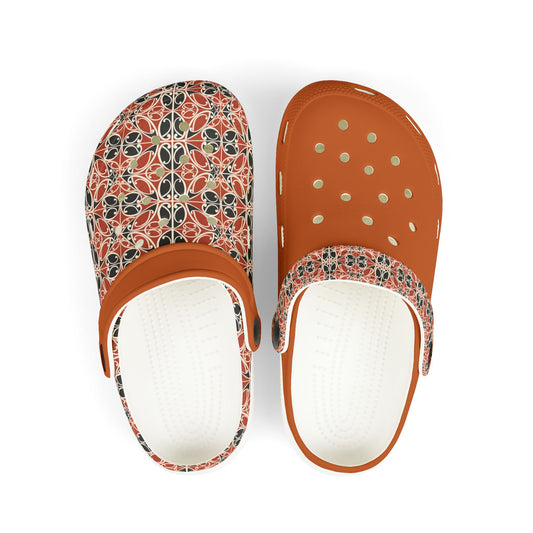 Māoritanga slip-on clogs with patterned upper, tan strap, and perforated toe