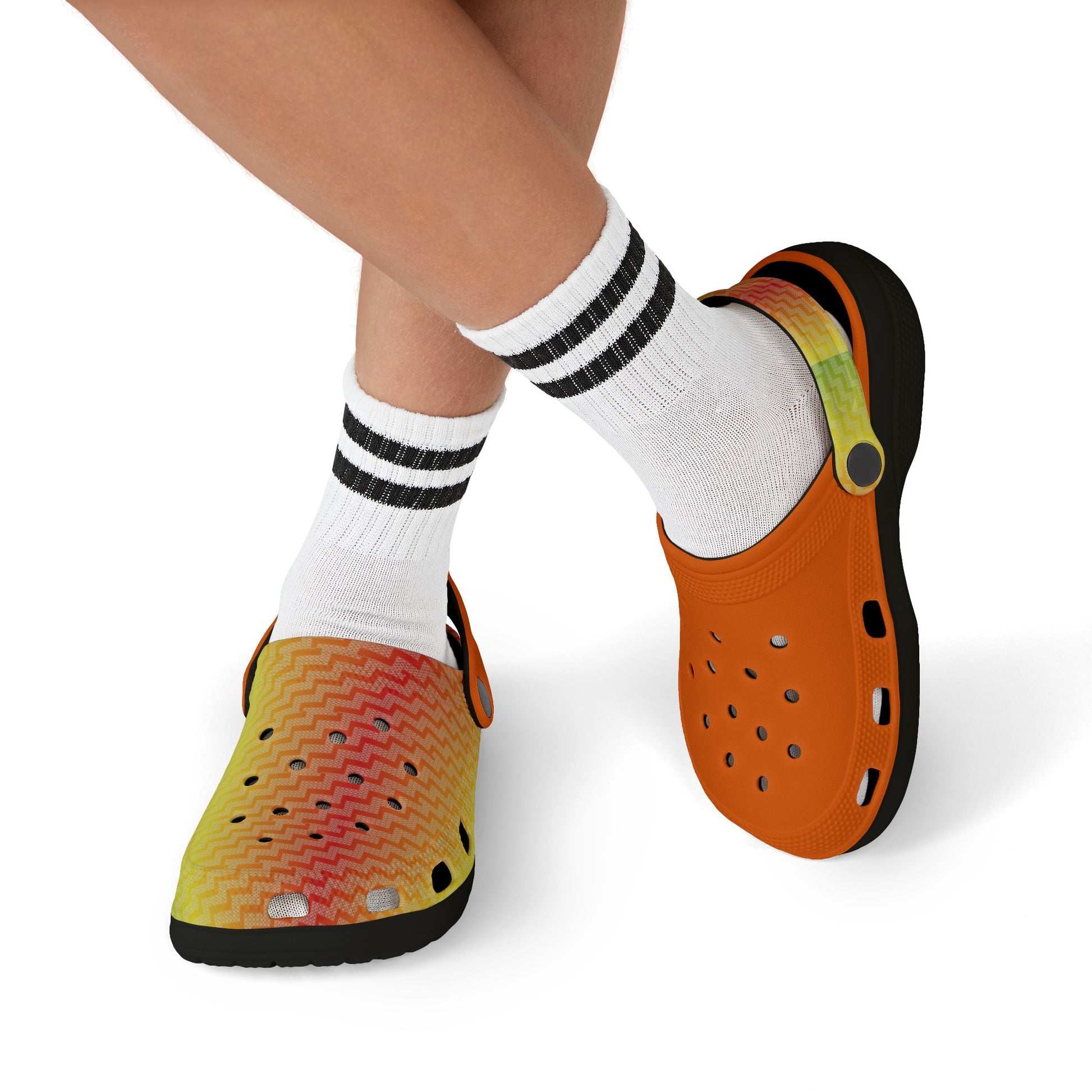 Orange clogs with perforations and black sole, worn with white striped socks.