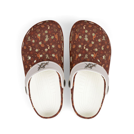 Printed casual clog shoes with white straps and open vents on maroon-brown fabric.