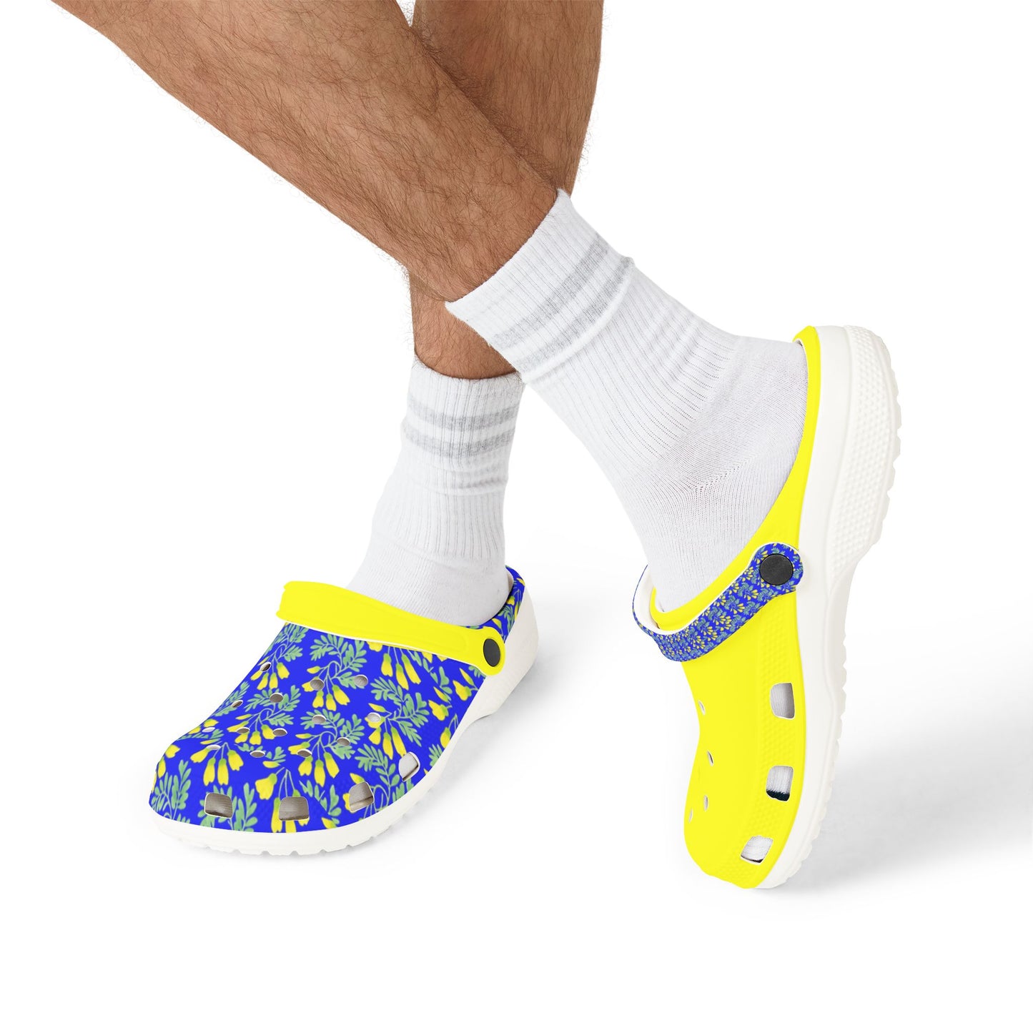 Kōwhai slip-on clogs on feet with white socks, yellow-and-blue uppers