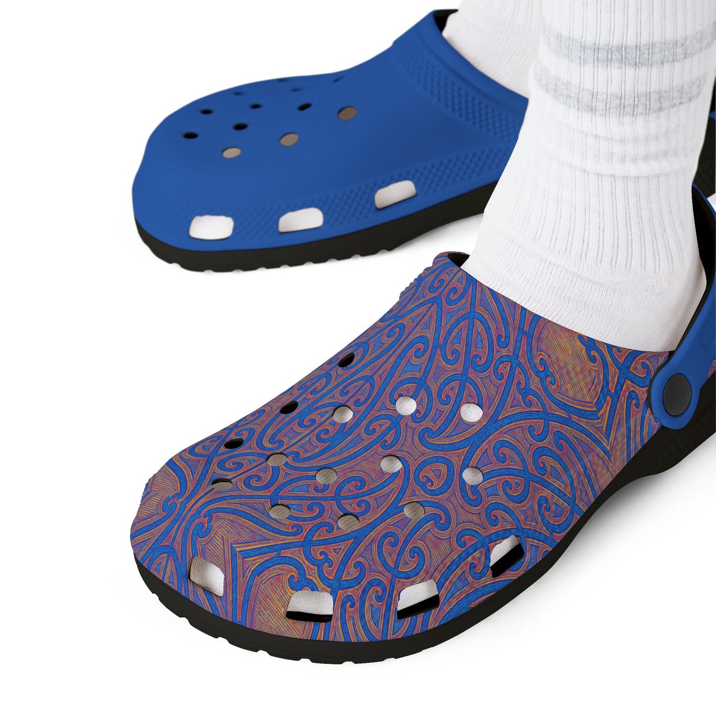 Pair of blue and purple patterned clogs worn with white socks.