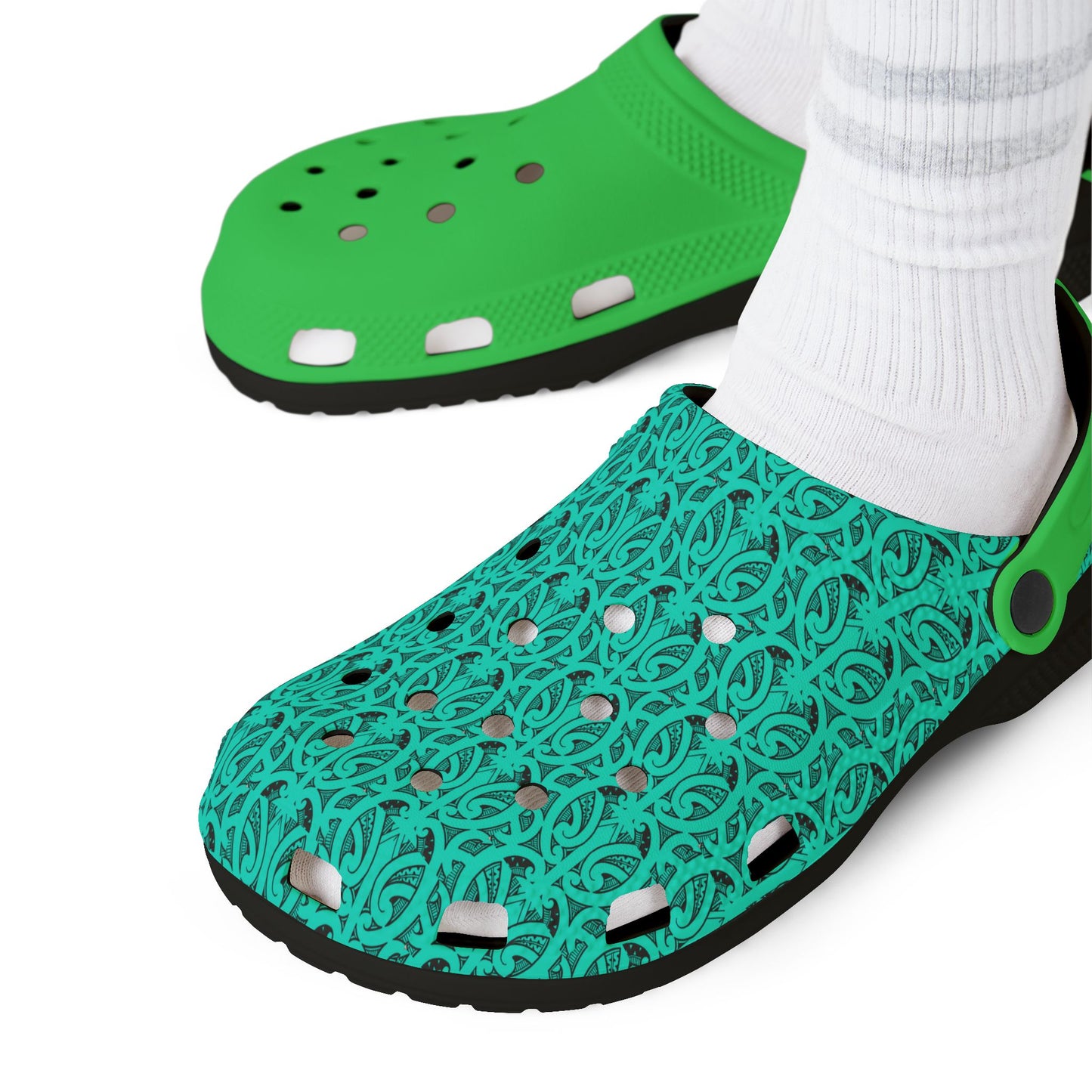 Green and teal patterned clogs with perforated toe holes and black outsole