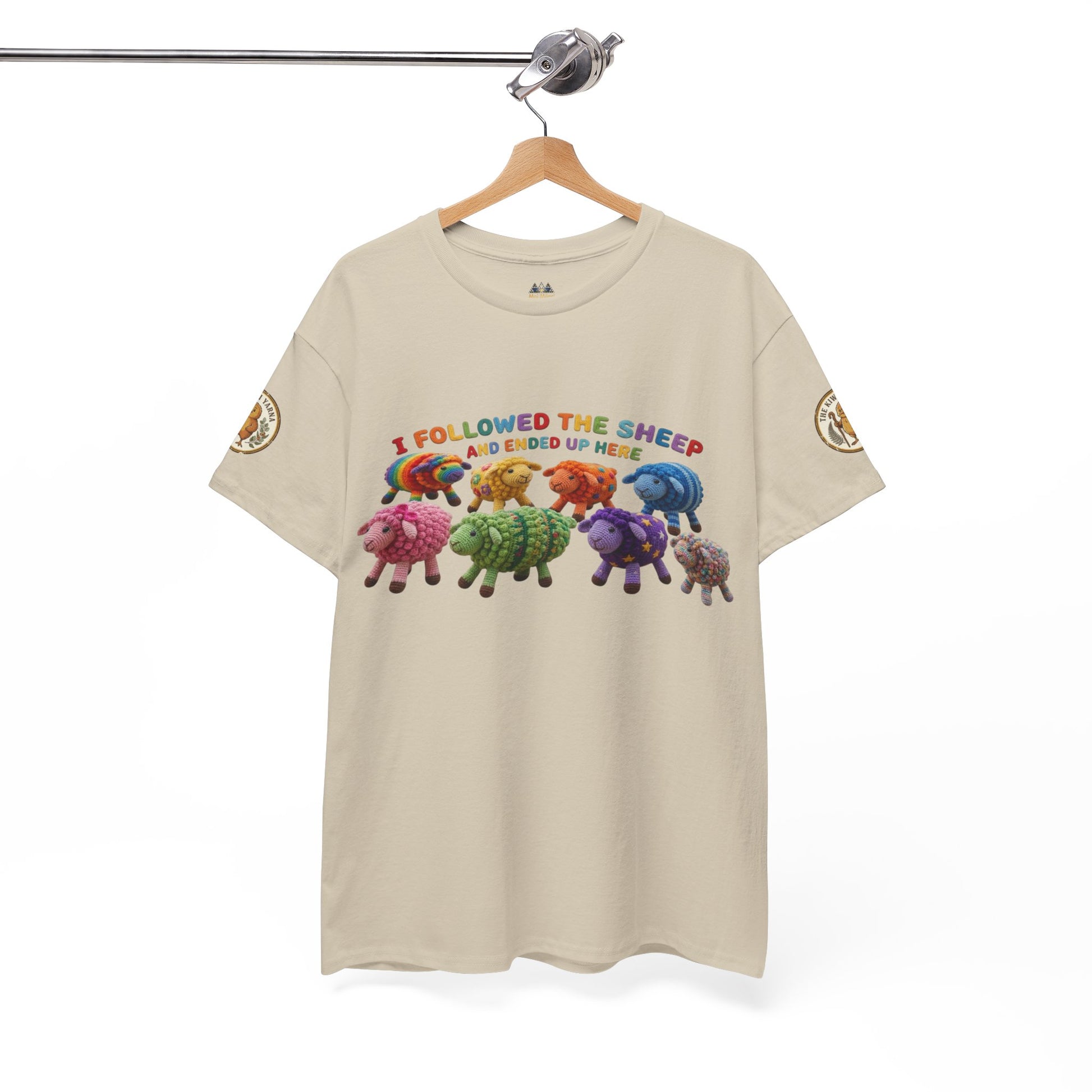 Beige short-sleeve T-shirt with colorful sheep graphic, hanging on a wooden hanger