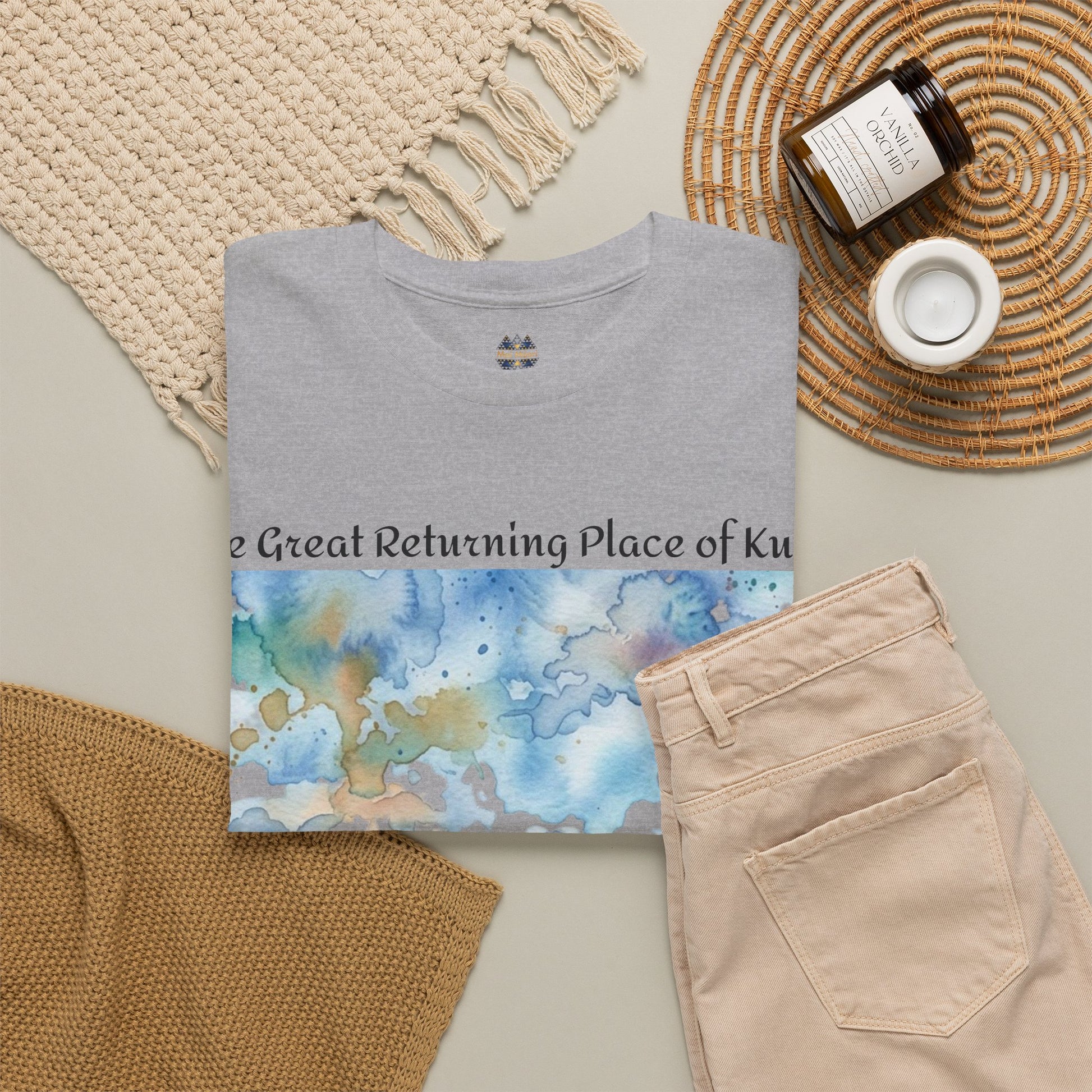 Sport grey graphic T-shirt with watercolor landscape print, laid with beige pants and textiles