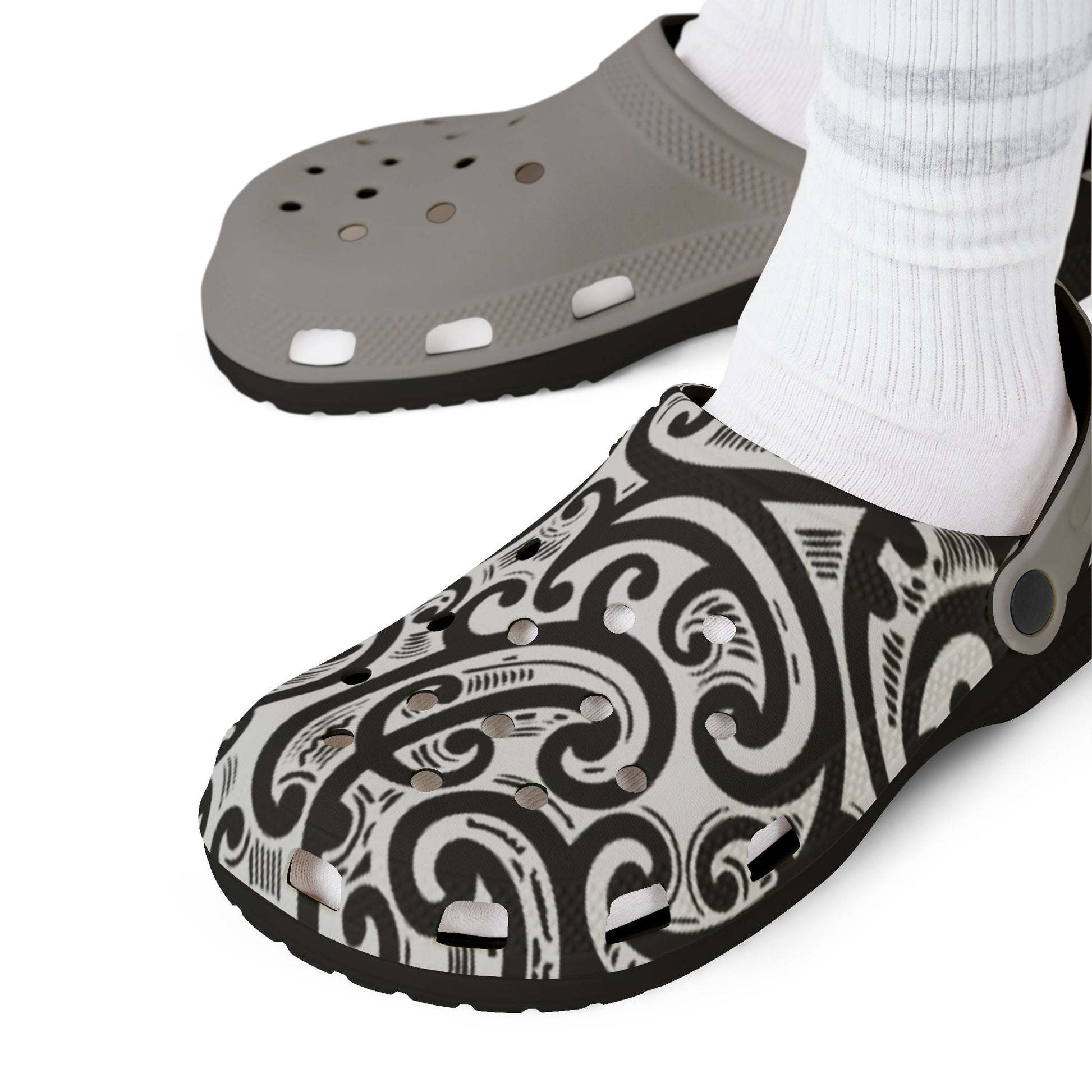 Croc-style clog pair with black-and-white patterned top and light gray perforated footbed