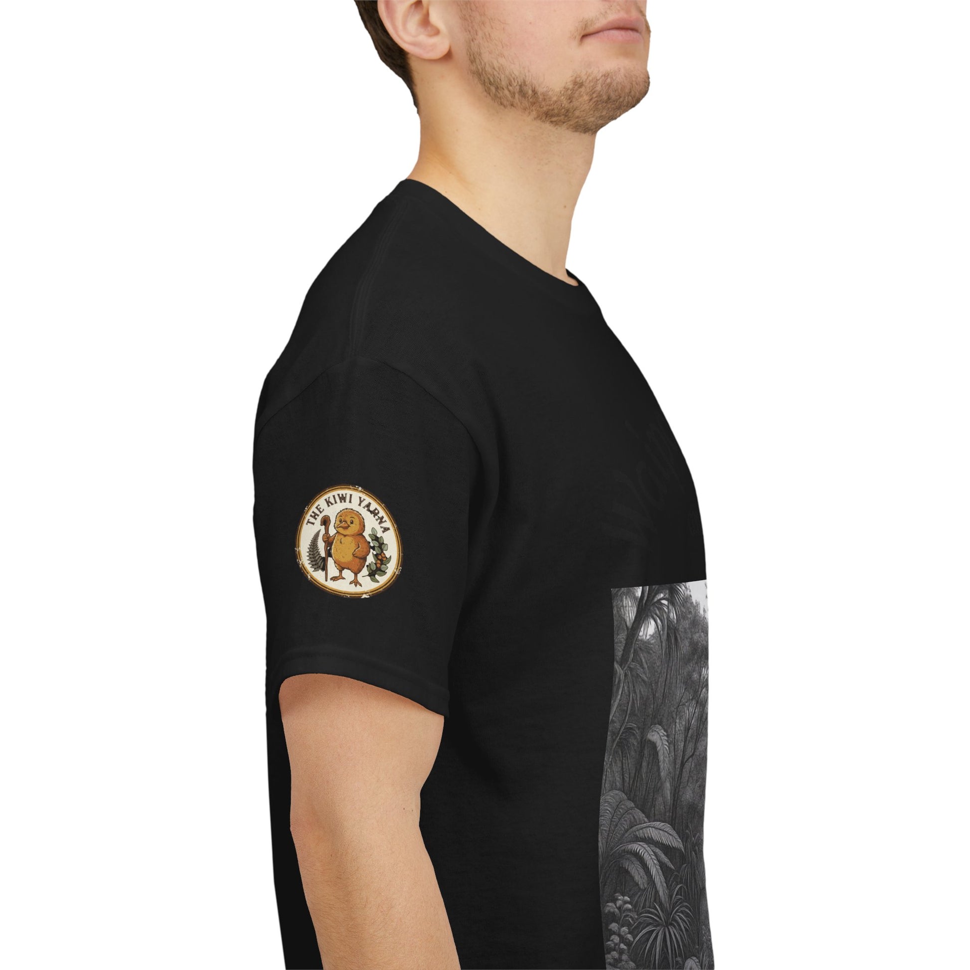 Black T-shirt side view with circular gold sleeve patch and part of grayscale forest print