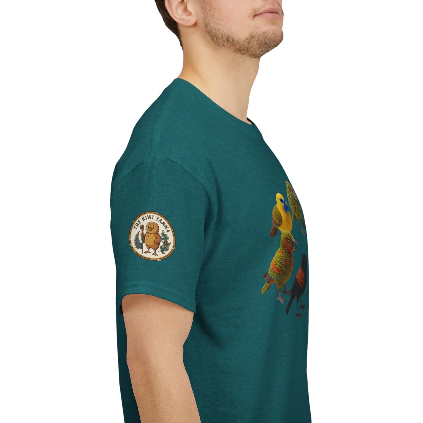 Teal T-shirt side view with round sleeve logo patch and colorful bird graphic