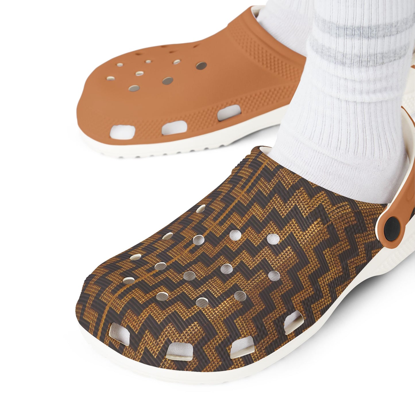 Pair of slip-on clogs on feet: tan perforated top and dark patterned upper
