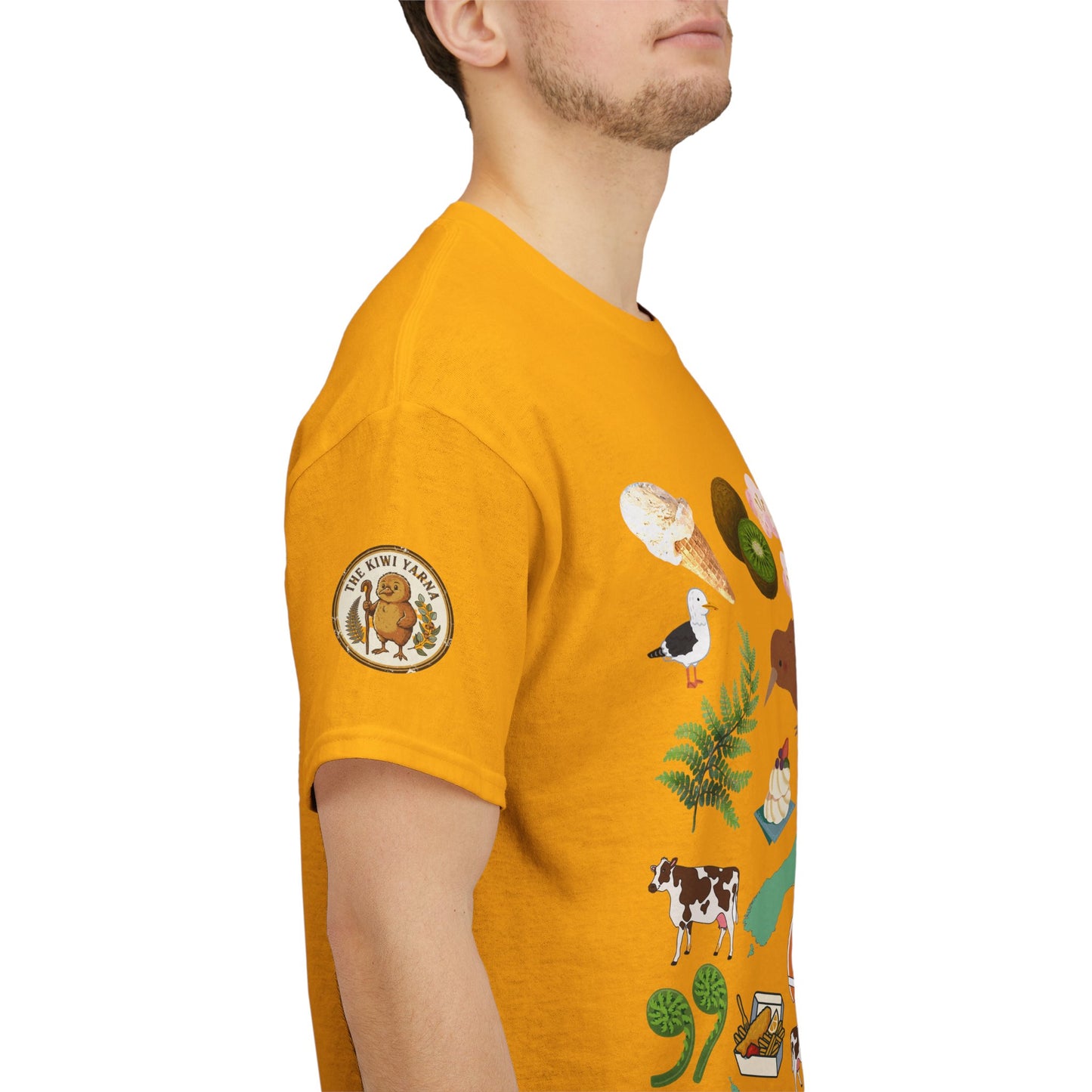 Mustard yellow graphic T-shirt, side view; sleeve badge with illustrated kiwi scene