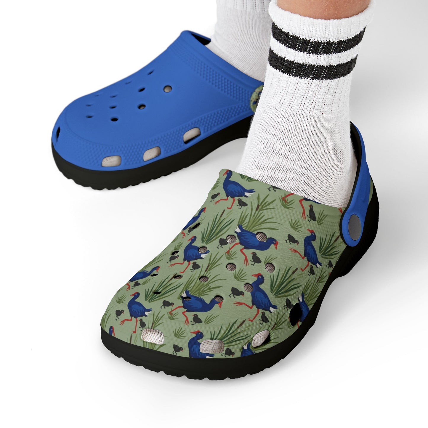 Kids clogs on feet: blue upper with patterned print, white socks, black outsole.