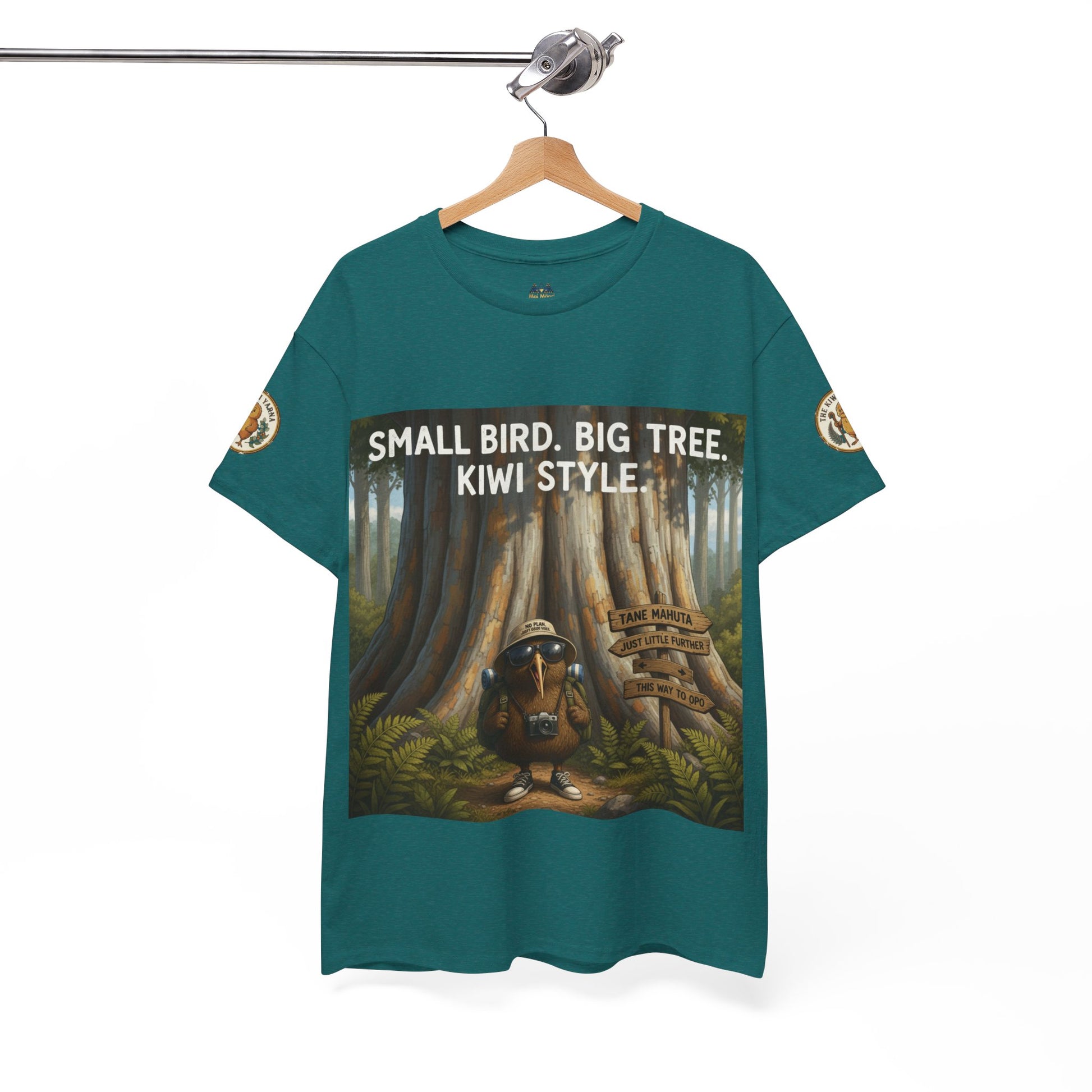 Teal graphic T-shirt on hanger with front woodland scene and “Kiwi Style” text