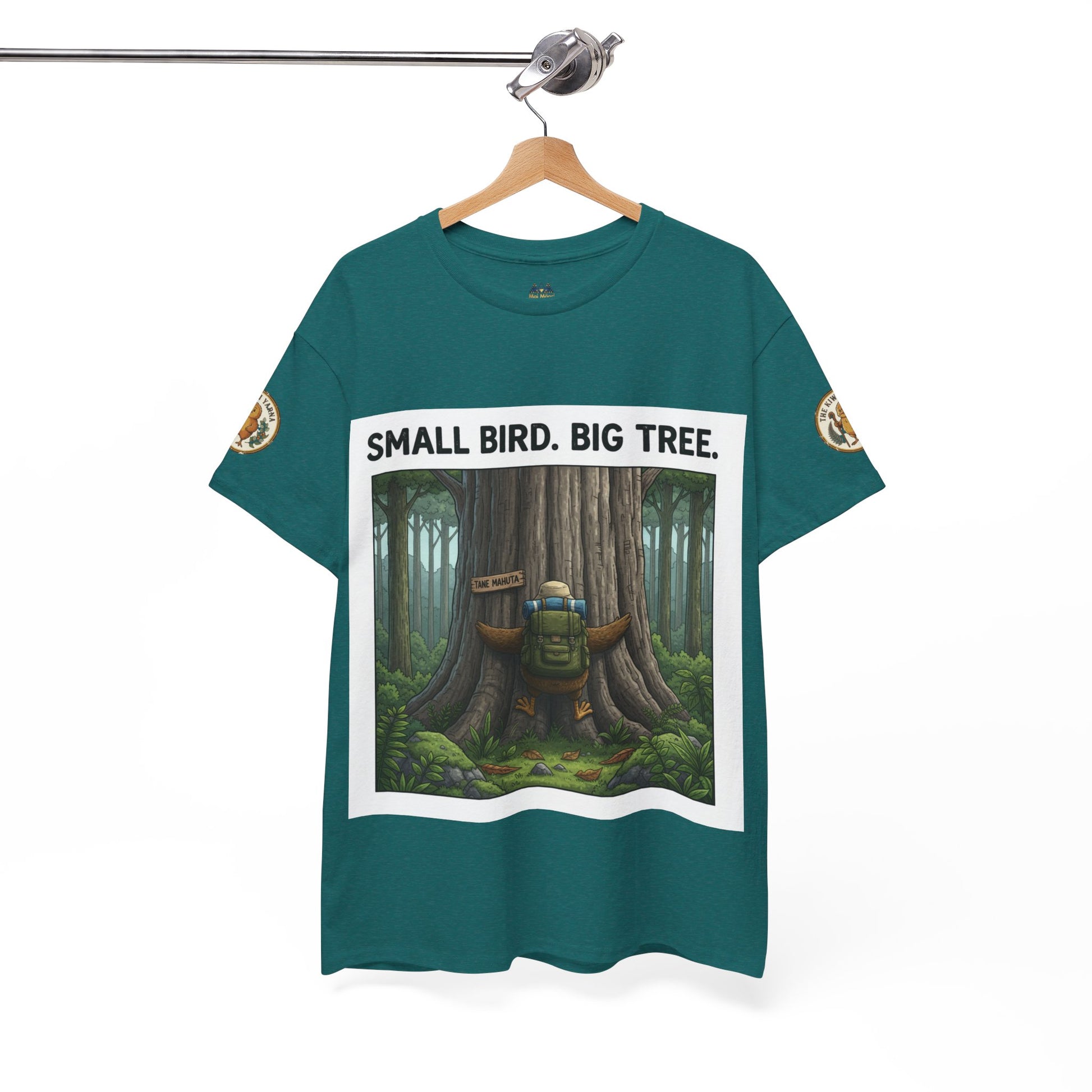 Teal crew-neck T-shirt on hanger with centered white-framed forest scene and sleeve patches