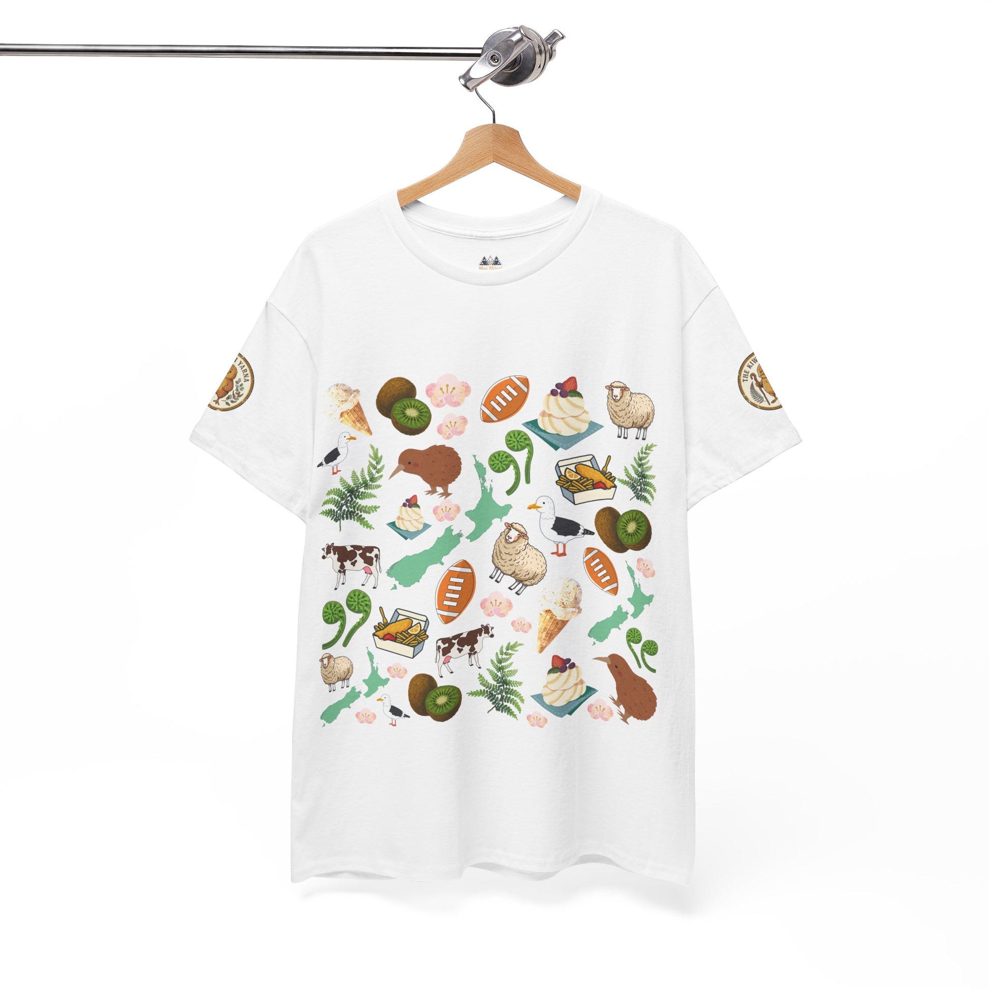 White T-shirt on hanger with Kiwiana collage graphic front and small sleeve badges