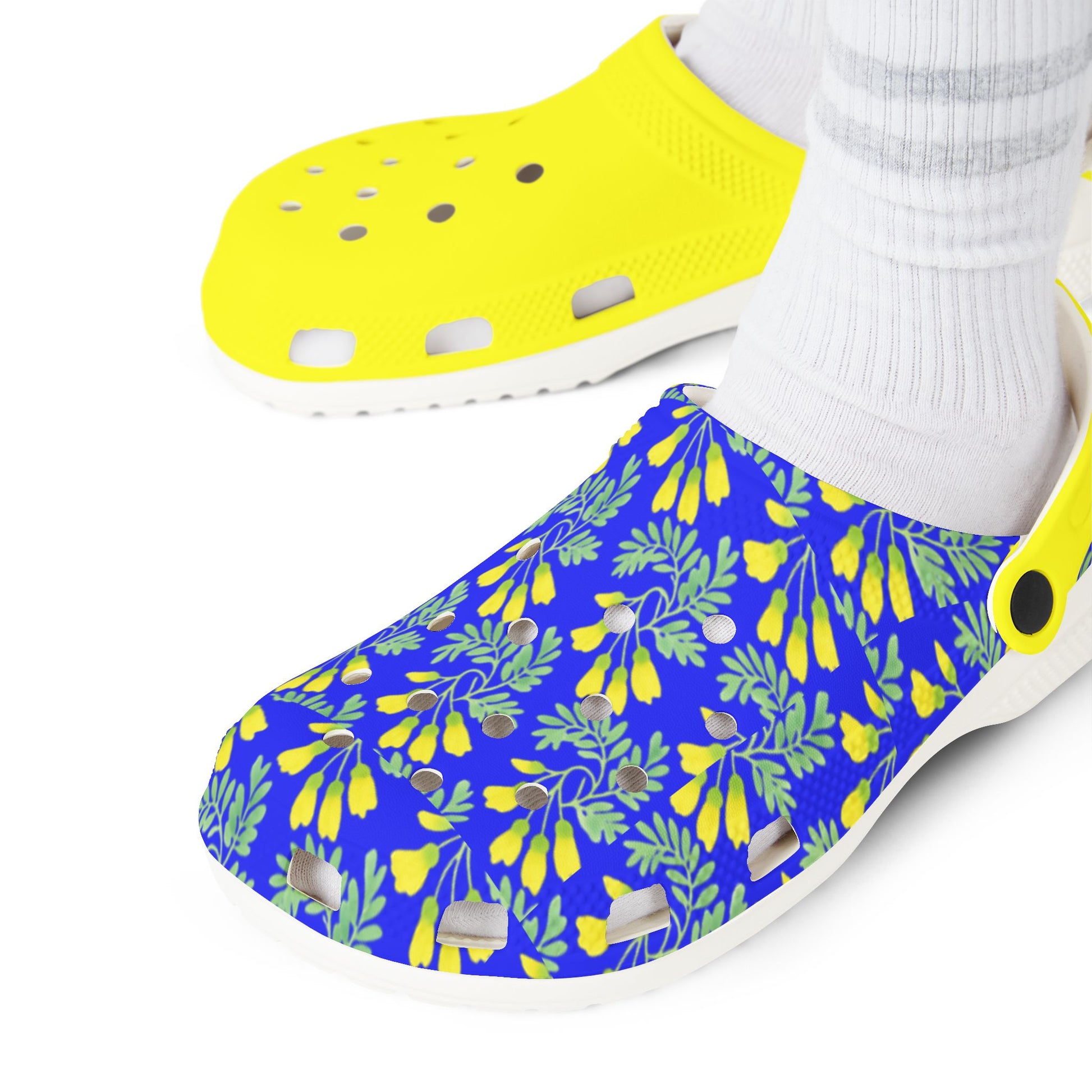 Kōwhai slip-on clogs, blue leaf print upper with yellow shoe, worn with white socks