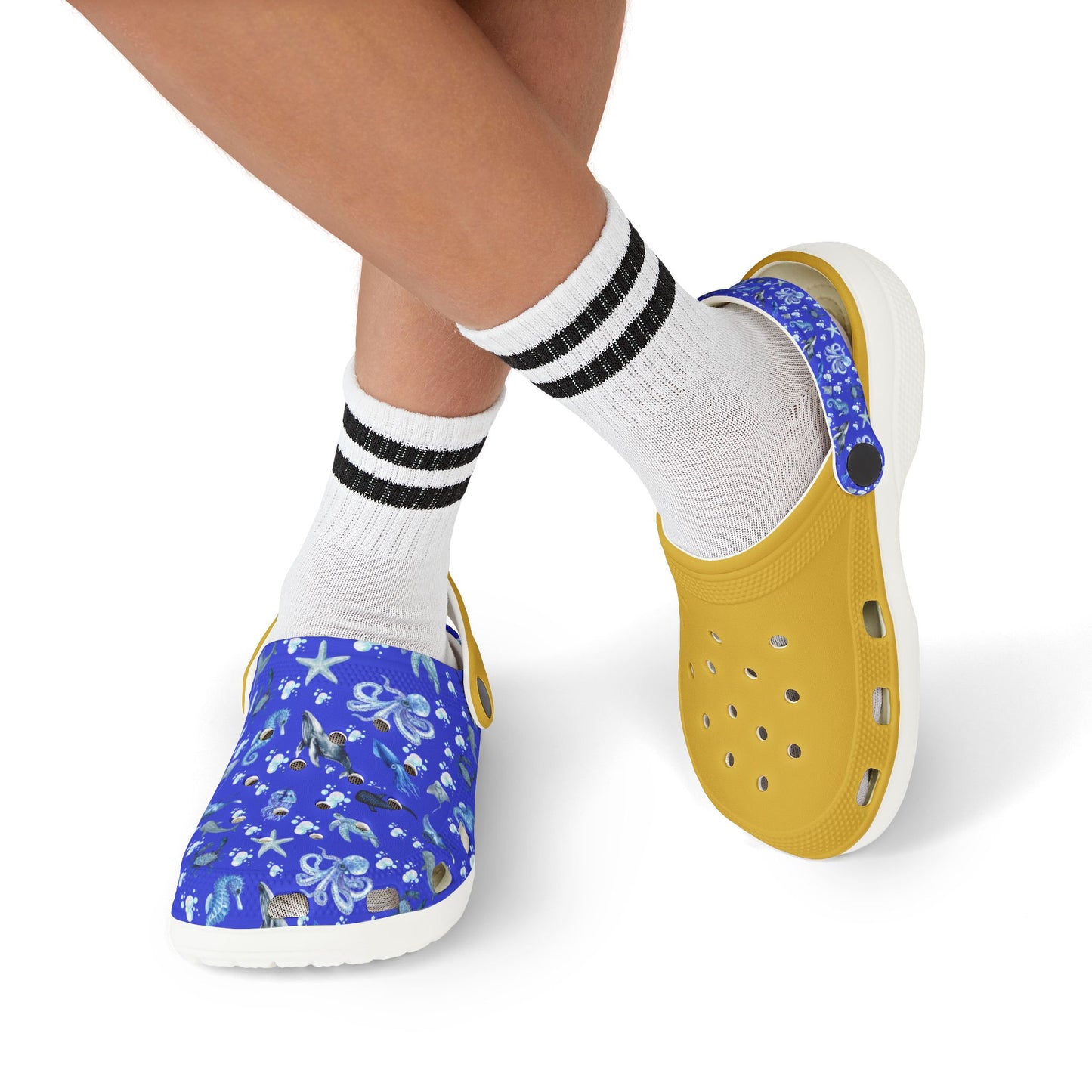 Kids' clog shoes on feet: blue sea-print shoe with yellow perforated back, white outsole.