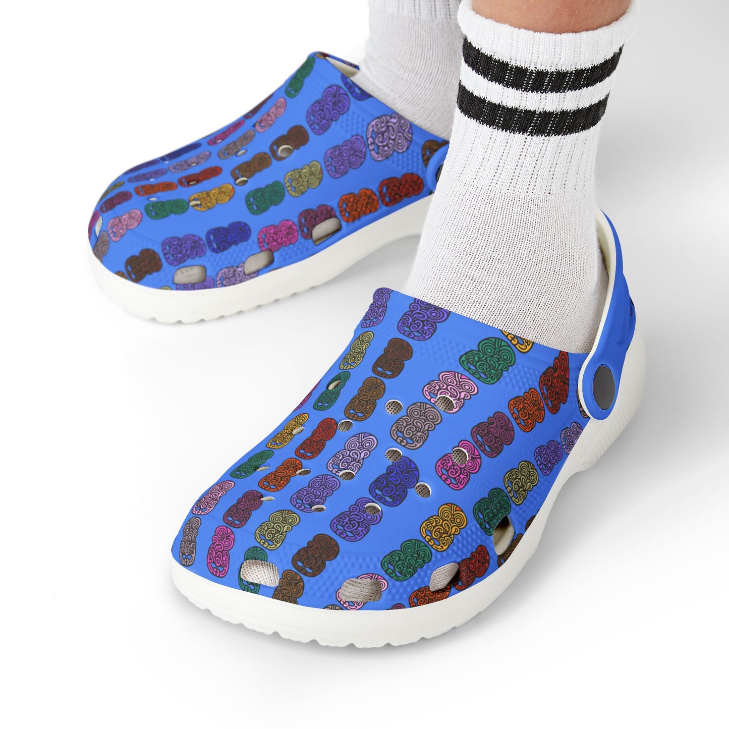 Kids slip-on casual shoe on foot with blue tiki-print upper, white sole, worn with socks